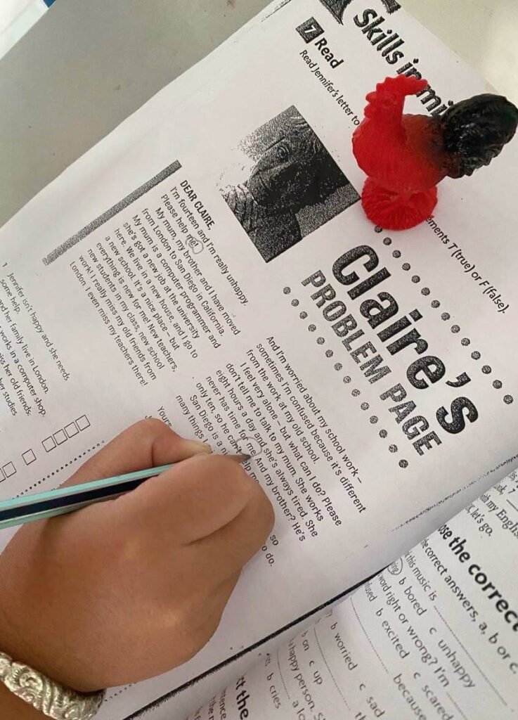 A pen circling the word 'me' inside a printed English storybook during a reading scavenger hunt.