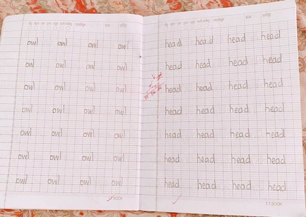 A page from a lined notebook filled with rows of the handwritten words "owl" and "head," with a red teacher's mark and a handwritten date of 05.06.2026.