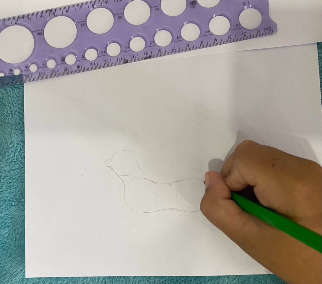 A child's hand connecting four pencil guide circles with light, curved strokes to create the outline of a dog's body and neck.